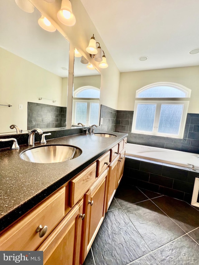 bathroom with a bath, double vanity, and marble finish flooring