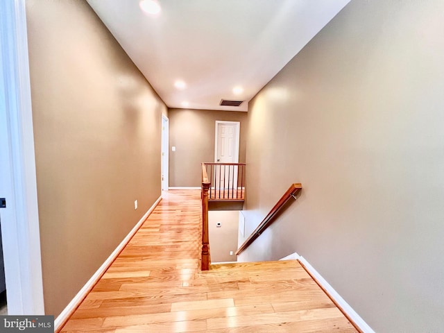hallway featuring an upstairs landing, wood finished floors, baseboards, and recessed lighting