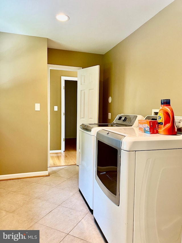 washroom featuring washer and clothes dryer, light tile patterned floors, recessed lighting, and baseboards