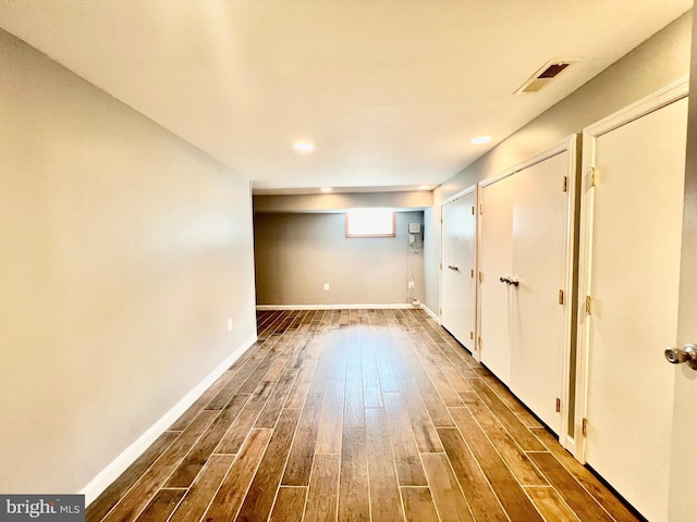below grade area with dark wood-style floors, baseboards, and recessed lighting
