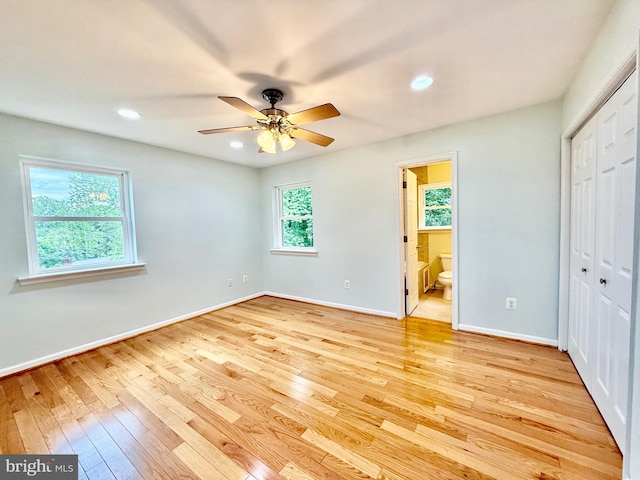 unfurnished bedroom featuring light wood-style floors, baseboards, ensuite bath, a closet, and recessed lighting