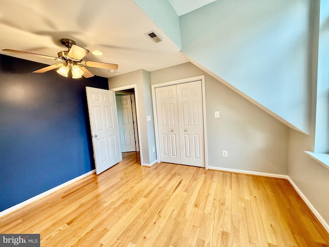 unfurnished bedroom with wood finished floors, baseboards, a closet, and a ceiling fan