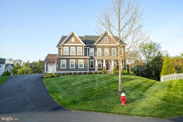 view of front facade featuring a standing seam roof, asphalt driveway, and metal roof