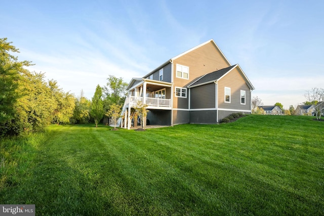 back of house with stairs, a lawn, and a deck