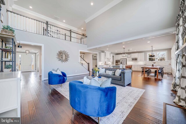 living area featuring stairs, crown molding, recessed lighting, dark wood-style floors, and baseboards