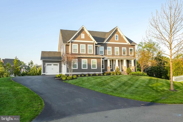 view of front of property featuring a standing seam roof, an attached garage, a porch, driveway, and metal roof
