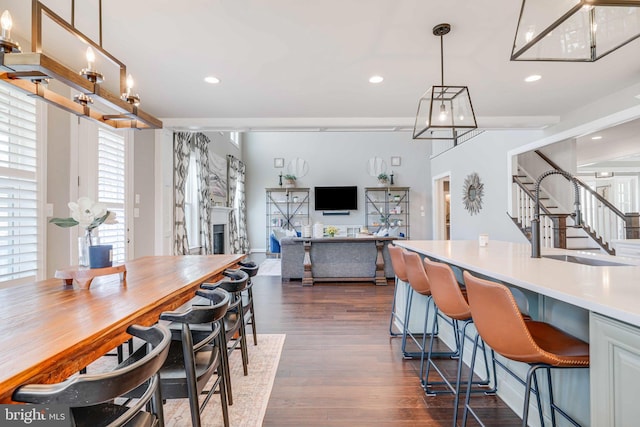 dining room featuring dark wood finished floors, a fireplace, stairway, and recessed lighting