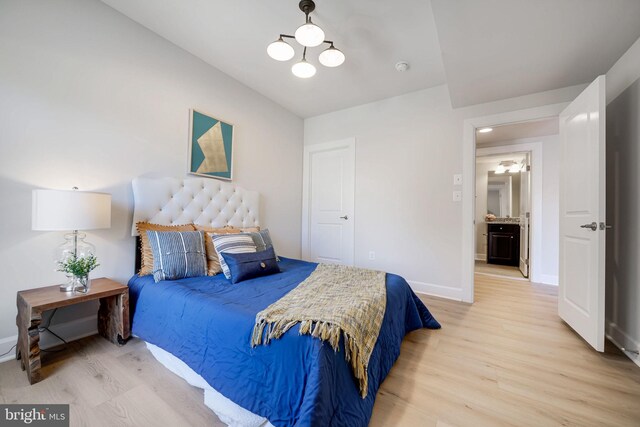 bedroom featuring light wood-type flooring, a chandelier, and baseboards
