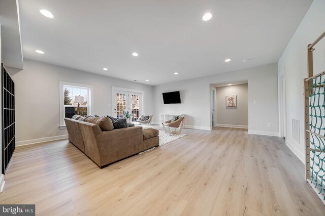 living area with light wood-type flooring, recessed lighting, baseboards, and french doors