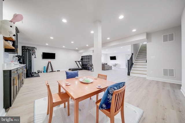 dining room featuring stairs, light wood-style flooring, recessed lighting, and baseboards