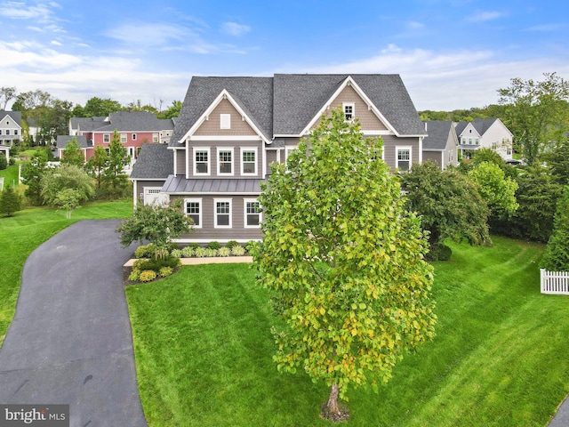 view of front of home featuring a standing seam roof, asphalt driveway, a garage, metal roof, and a front lawn