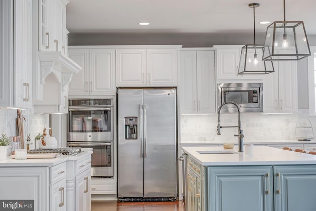 kitchen with stainless steel appliances, a sink, backsplash, white cabinetry, and recessed lighting
