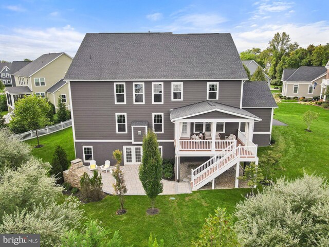 rear view of property featuring a patio and stairs