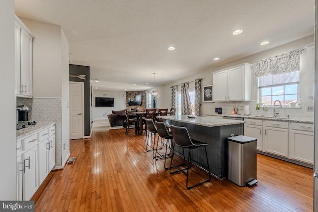 269 Bucktail Dr, Middletown, DE 19709 - kitchen with a sink, open floor plan, white cabinets, a kitchen breakfast bar, and light wood finished floors