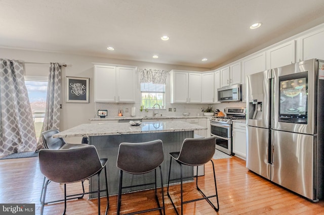 269 Bucktail Dr, Middletown, DE 19709 - kitchen featuring appliances with stainless steel finishes, a sink, light wood-type flooring, white cabinets, and recessed lighting