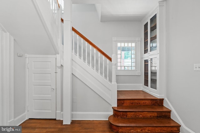 stairway featuring wood finished floors and baseboards