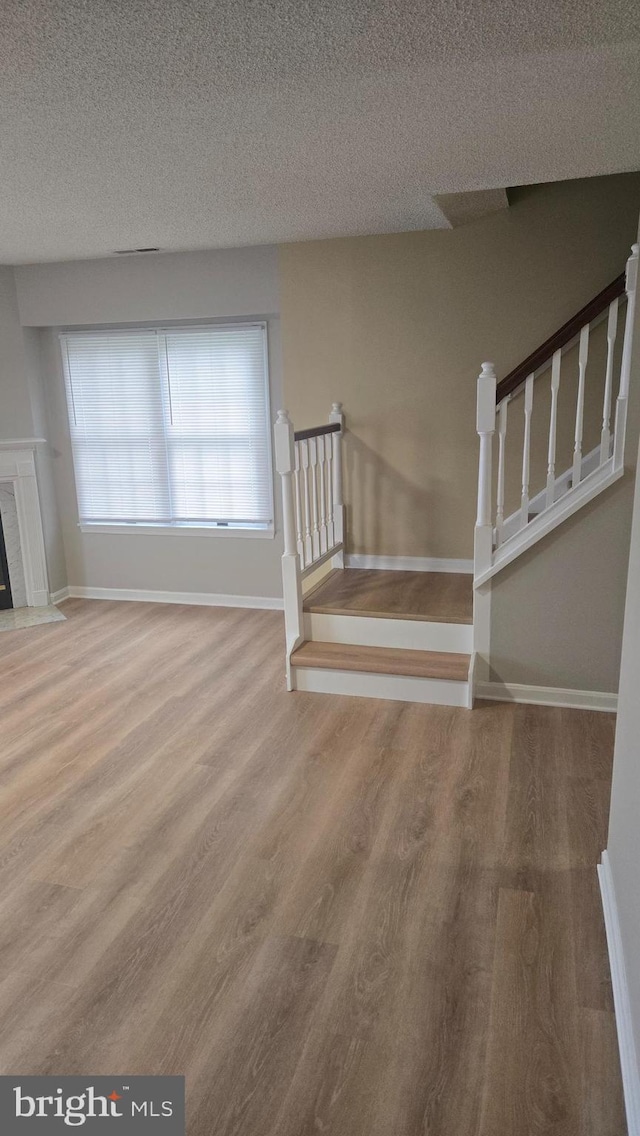 38261 Yacht Basin Rd Unit 35, Ocean View, DE 19970 - stairs featuring wood finished floors, a textured ceiling, and a fireplace