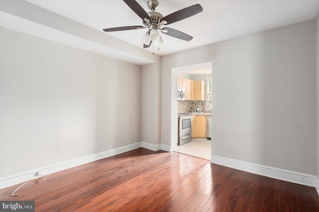 15 N Belnord Ave, Baltimore, MD 21224 - empty room with light wood finished floors and a ceiling fan