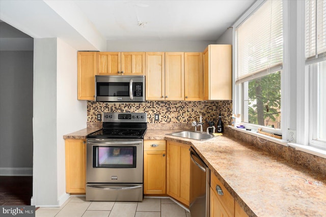 15 N Belnord Ave, Baltimore, MD 21224 - kitchen with stainless steel appliances, tasteful backsplash, light brown cabinets, and light tile patterned flooring