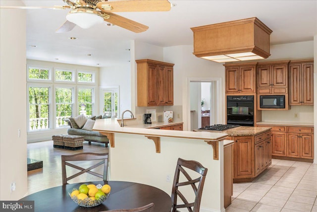2630 Eagle Ln, Hellertown, PA 18055 - kitchen featuring black appliances, a breakfast bar, tasteful backsplash, light countertops, and a peninsula