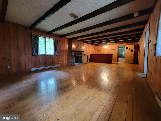 13337 Rowe Rd, Smithsburg, MD 21783 - unfurnished living room with a baseboard radiator, wood walls, beamed ceiling, wood-type flooring, and a fireplace