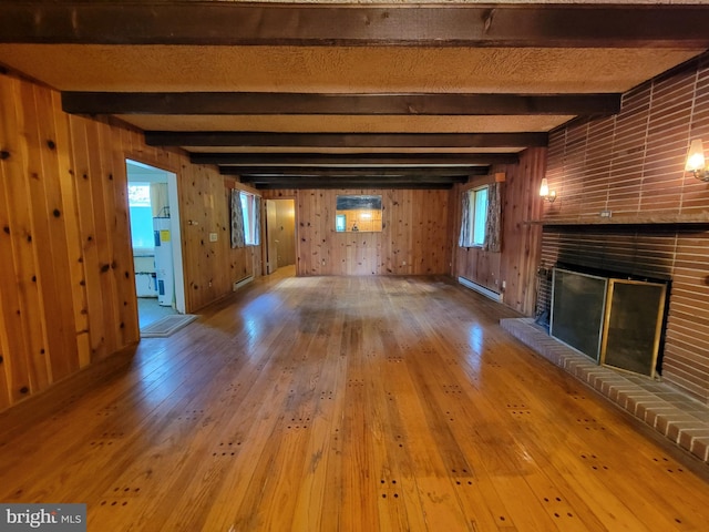 13337 Rowe Rd, Smithsburg, MD 21783 - unfurnished living room featuring a baseboard radiator, a fireplace, wood-type flooring, wooden walls, and beamed ceiling