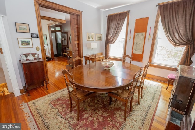 dining area with light wood finished floors and baseboards