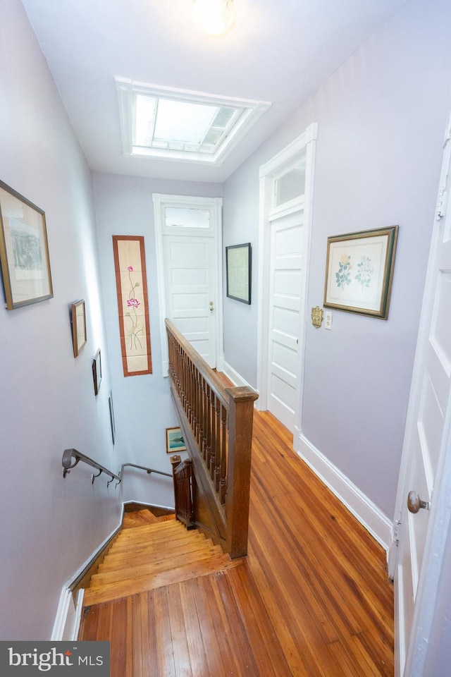 stairs featuring hardwood / wood-style flooring and baseboards