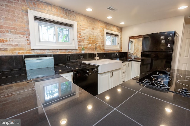 kitchen with black appliances, dark countertops, white cabinets, healthy amount of natural light, and recessed lighting