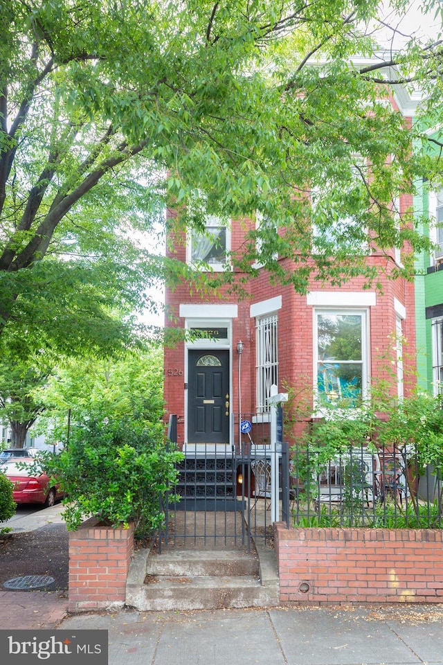 entrance to property with brick siding and fence