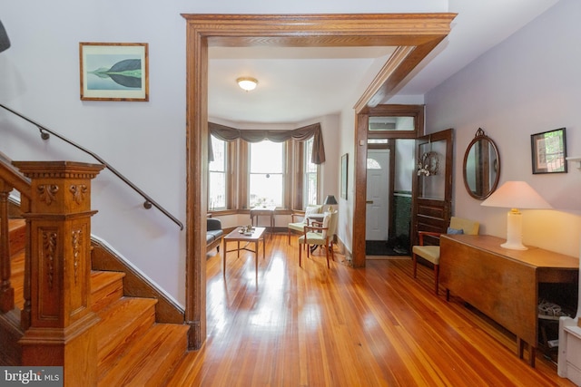 foyer entrance featuring stairs, wood finished floors, and baseboards