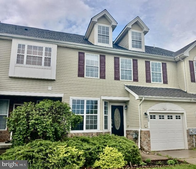multi unit property featuring an attached garage and stone siding
