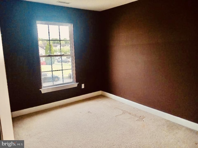 empty room with plenty of natural light and carpet flooring