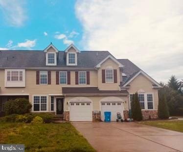 view of front facade with a garage, driveway, and a front lawn
