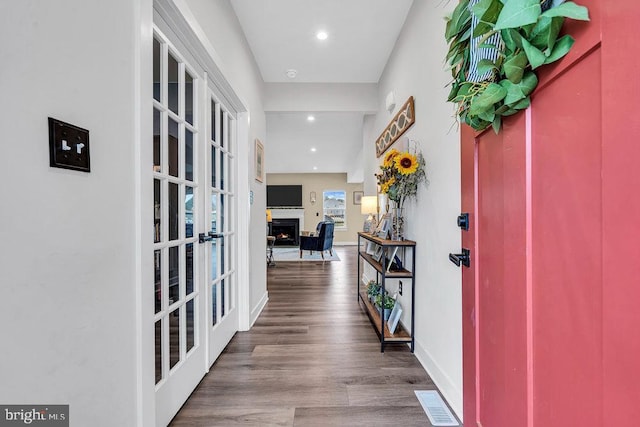 corridor with french doors, wood finished floors, recessed lighting, and baseboards