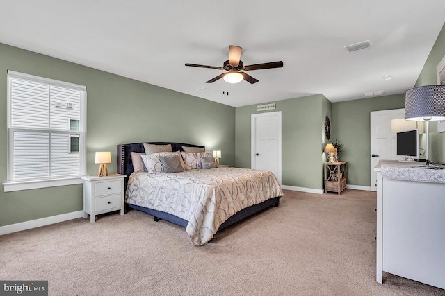 bedroom featuring light colored carpet, baseboards, and a ceiling fan