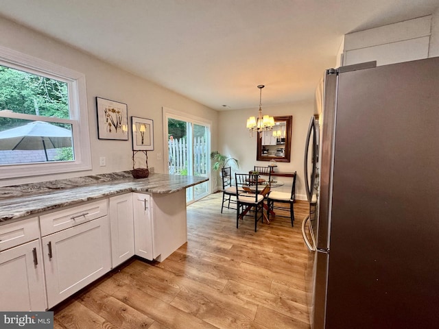 1410 Foxwood Ct, Annapolis, MD 21409 - kitchen with freestanding refrigerator, white cabinets, light wood-style floors, and plenty of natural light