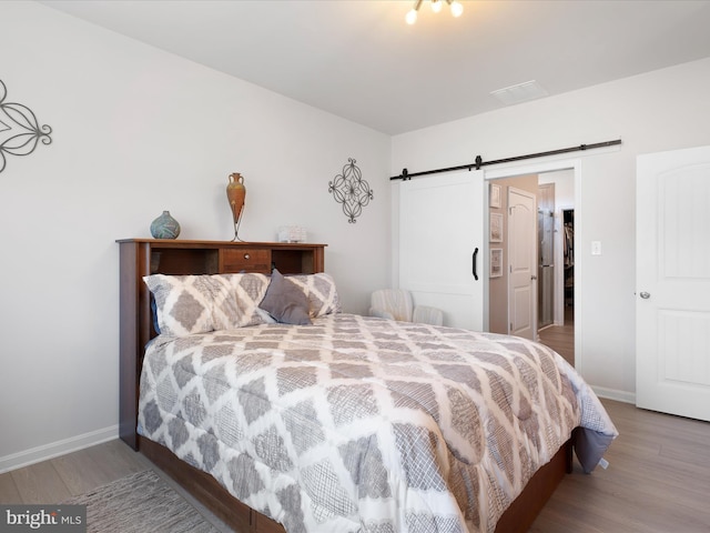 832 Red Maple Rd, Smyrna, DE 19977 - bedroom featuring a barn door, wood finished floors, and baseboards