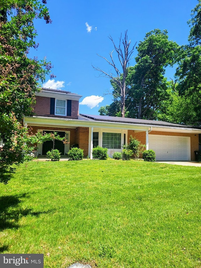 7100 Beltz Dr, District Heights, MD 20747 - view of front facade featuring a garage, a front lawn, brick siding, and driveway
