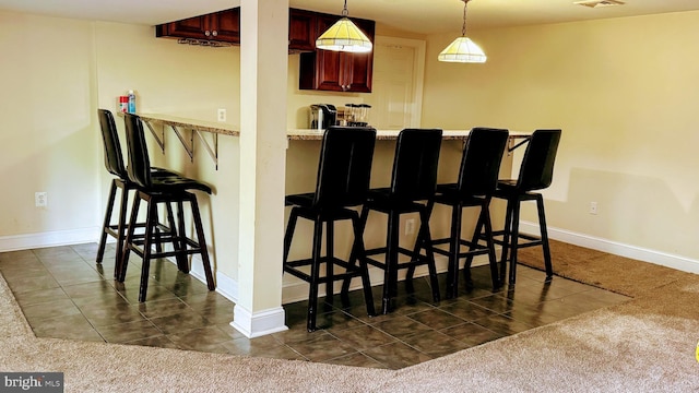7100 Beltz Dr, District Heights, MD 20747 - indoor bar featuring baseboards, dark carpet, decorative light fixtures, and dark tile patterned flooring