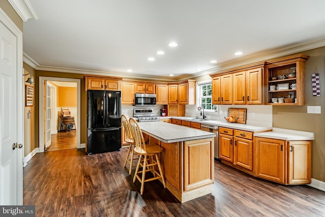 41 Diane Dr, Honey Brook, PA 19344 - kitchen featuring appliances with stainless steel finishes, ornamental molding, dark wood finished floors, a kitchen island, and a kitchen breakfast bar