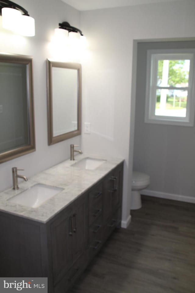 1296 Dorchester Ave, Pocomoke City, MD 21851 - full bath with wood finished floors, toilet, double vanity, and baseboards