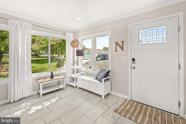 foyer entrance with ornamental molding and baseboards