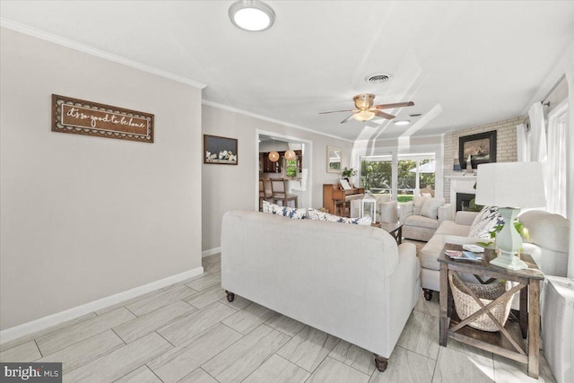 living area featuring ceiling fan, a fireplace, baseboards, and ornamental molding