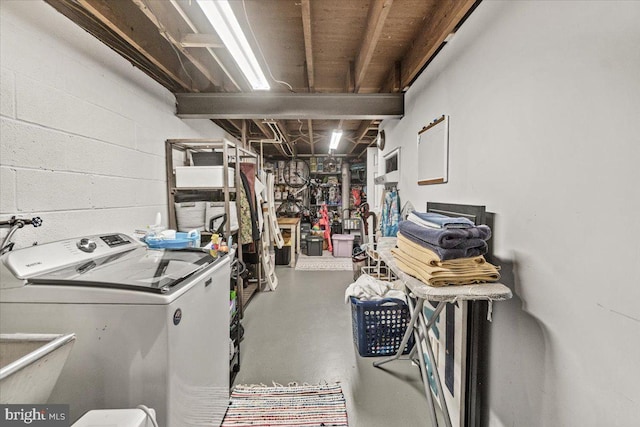 unfinished below grade area featuring washing machine and dryer and a sink