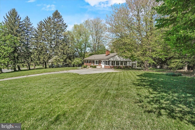 view of front of property with a front yard, a chimney, and a patio area