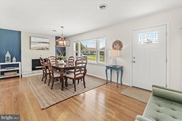dining room with healthy amount of natural light, light wood finished floors, and a chandelier