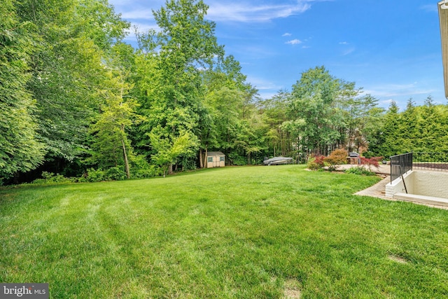 5513 Notched Beak Ct, Waldorf, MD 20601 - view of green lawn featuring a storage unit and a wooded view