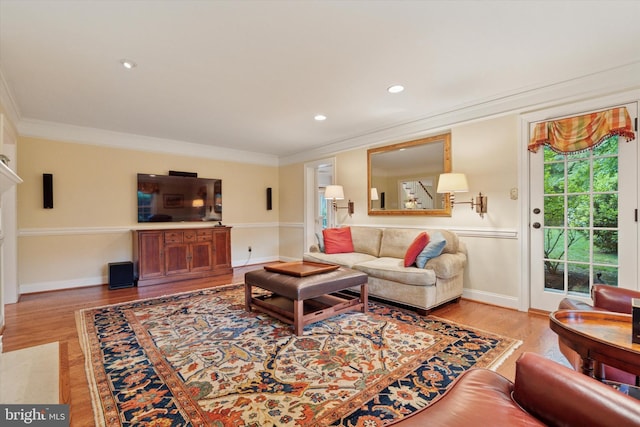 living area with crown molding, healthy amount of natural light, wood finished floors, baseboards, and recessed lighting