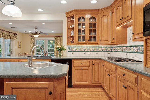 kitchen featuring stainless steel gas stovetop, light wood-type flooring, a ceiling fan, recessed lighting, and glass insert cabinets